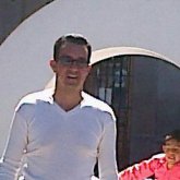 Delgado, moreno claro, pelo negro corto.